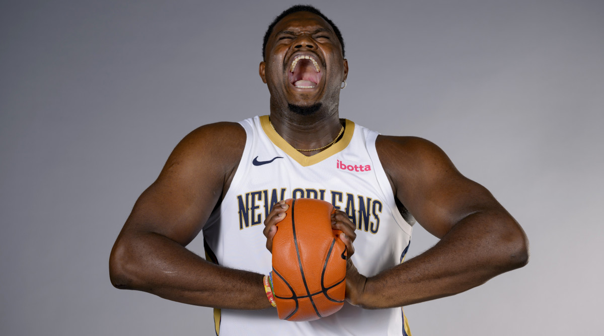 New Orleans Pelicans forward Zion Williamson crushes a basketball while posing during Pelicans’ NBA media day.